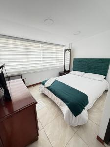 Un dormitorio con una cama grande y una mesa de madera. en Hotel Hierbabuena y Restaurante, en Pasto 20 fotos más