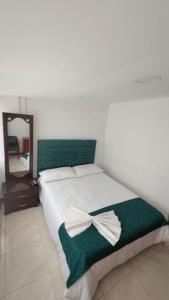 a bedroom with a bed with a bow on it at Hotel Hierbabuena y Restaurante in Pasto +9 photos