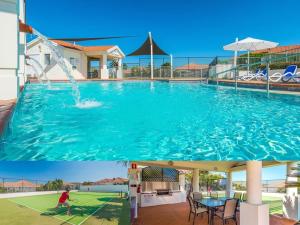 een groot zwembad met een persoon die erin speelt bij Beach Street - LJHooker Yamba in Yamba