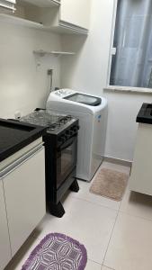 eine Küche mit Herd oberer Ofen neben einem Fenster in der Unterkunft Casa térrea 2 suítes condomínio in Lauro de Freitas + 14 Fotos