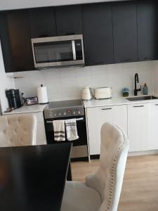 eine Küche mit Herd und Mikrowelle in der Unterkunft Stockyards in Toronto