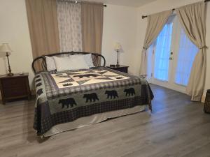 een slaapkamer met een bed met een deken erop bij Mallard Cove - lakeside pet friendly in Robbinsville