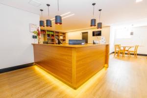 a large wooden counter in a room with a table at Hotel Move BH in Belo Horizonte