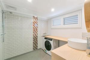 a bathroom with a washing machine and a shower at Endless Horizon in Kingscliff