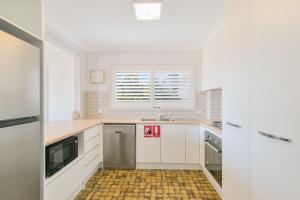 a kitchen with white cabinets and a window at Endless Horizon in Kingscliff