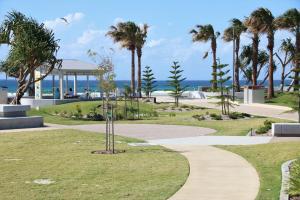 a park with palm trees and a walkway at Endless Horizon in Kingscliff +13 photos