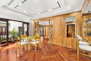 会安Wafaifo Resort Hoi An的用餐室设有木镶板和桌椅 更多87张照片