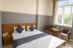 a bedroom with a bed and two chairs and a window at 10h Hotel in Ho Chi Minh City +34 photos