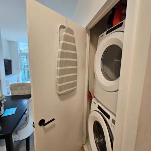 eine Küche mit Waschmaschine und Mikrowelle in der Unterkunft Stockyards in Toronto