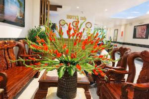 a vase filled with orange flowers on a table at 10h Hotel in Ho Chi Minh City