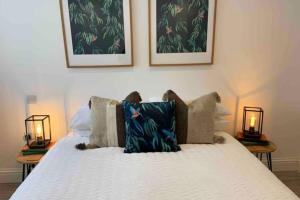 a bed with two lamps on the side of it at New contemporary apartment in centre of Tetbury in Tetbury