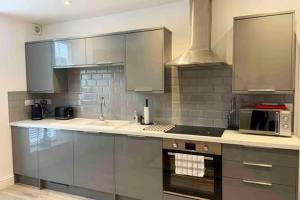 a kitchen with stainless steel cabinets and a stove at New contemporary apartment in centre of Tetbury in Tetbury +13 photos