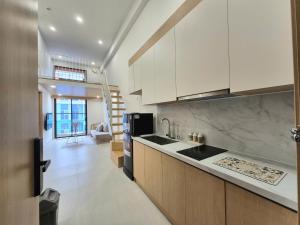 una cucina con mobili bianchi e un piano di lavoro di My SunArt a Quang Ãm