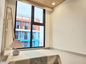 una camera da letto con una grande finestra e un tavolo con una lampada di My SunArt a Quang Ãm