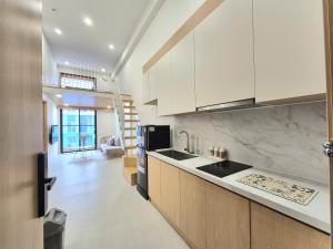 una cucina con mobili bianchi e un piano di lavoro di My SunArt a Quang Ãm