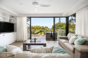 ein Wohnzimmer mit Sofa und Fernseher in der Unterkunft Salty Stays on Stevens St Ocean Views Top Deck in Sunshine Beach