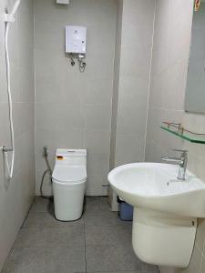 a bathroom with a toilet and a sink at Hạt Nắng House - Gò Vấp in Ho Chi Minh City