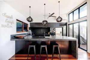 een keuken met een groot eiland met barkrukken bij Absolute Beachfront House with Pool & Views in Marcus Beach +10 foto's