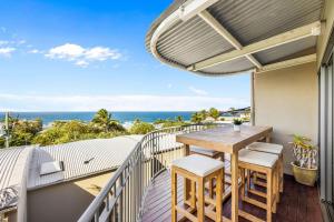 einen Balkon mit einem Holztisch, Stühlen und Meerblick in der Unterkunft 8 Andari Sunshine Luxury 1min to Beach in Sunshine Beach + 2 Fotos