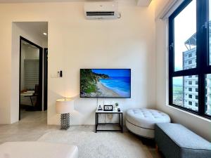 a living room with a large window and a tv on the wall at Aston Acacia Residence Bukit Mertajam in Bukit Mertajam