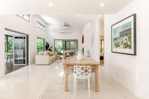 Un comedor y una sala de estar con mesa y sillas. en Sleek Stylish Family Beach House Near Junction, en Noosa Heads 9 fotos más