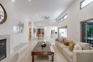 una sala de estar con un sofá y una mesa en Sleek Stylish Family Beach House Near Junction, en Noosa Heads