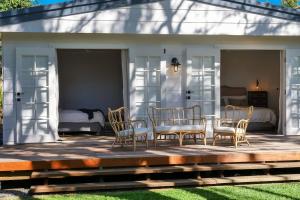 1 dormitorio y patio con mesa y sillas. en The River Shack Vintage Luxe Right Beside River, en Noosaville