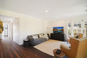 una sala de estar con un sofá y sillas en The River Shack Vintage Luxe Right Beside River, en Noosaville