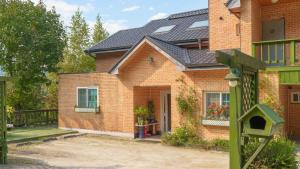 a brick house with a bird house in front of it at yangpyeong beulleosseom pet spa pension in Yangpyeong