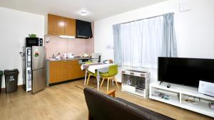 a living room with a couch and a kitchen at Dream Tree 札幌市电步行0分钟 超市步行1分钟 in Sapporo