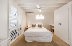 Un dormitorio blanco con una cama blanca y una ventana. en The Rest Family Cottage with Resort Style Pool, en Noosa Heads 67 fotos más