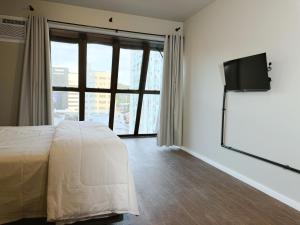 a bedroom with a bed and a flat screen tv at Smart Stay Lofts in Joinville