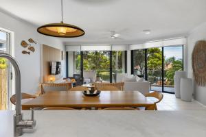 a kitchen and living room with a table and chairs at Unit 3 21 Park Generous and Comfortable Beachside Abode in Sunshine Beach
