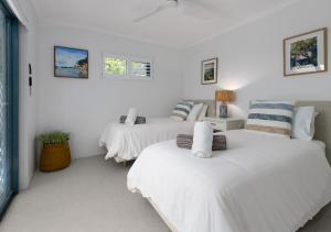 two beds in a room with white walls at Unit 3 21 Park Generous and Comfortable Beachside Abode in Sunshine Beach