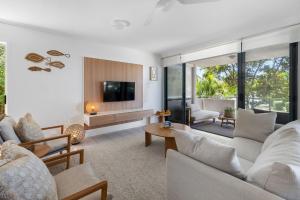 a living room with white furniture and a tv at Unit 3 21 Park Generous and Comfortable Beachside Abode in Sunshine Beach