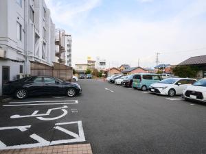 een rij auto's geparkeerd op een parkeerplaats bij Okasan Hotel in Ogaki