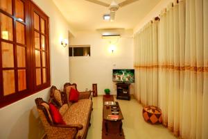 a living room with a couch and a tv at Orchidee Apartments in Mount Lavinia