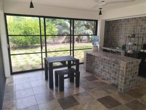 a kitchen with two stools and a table and windows at Casa Ix Milagros in Huay Pix