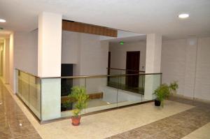 a lobby with glass railing and two potted plants at Complex Hunter's Beach in Shkorpilovtsi +152 photos