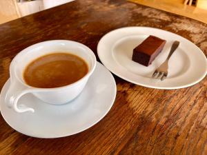 een kop koffie en een stuk taart op een tafel bij Powder Base Naeba in Yuzawa