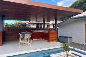un patio con un bar e un tavolo accanto a una piscina di Villa Noa Vai a Irioa