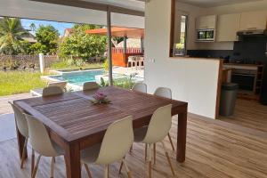 una cucina e una sala da pranzo con tavolo e sedie in legno di Villa Noa Vai a Irioa
