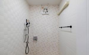 a shower in a bathroom with a phone on the wall at Baan Iris Salaya in Salaya