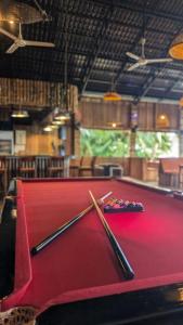 un tavolo da biliardo con due stecche sopra di The Up Koh Rong a Phumĭ Kâoh Rŏng 1 altra foto