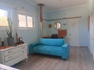 un canapé bleu dans un salon avec un miroir dans l'établissement Casa en el quisco 10 personas con piscina, à El Quisco