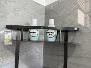 a glass shelf with two bottles of shower gel at Turtle Bay Resort Hikkaduwa in Hikkaduwa +35 photos