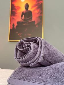 un asciugamano arrotolato appoggiato su un letto con una foto di Ban Supattra a Ban Khlong Mat