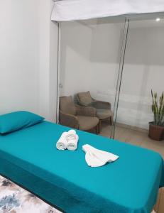 ein Bett mit zwei weißen Handtüchern darüber in der Unterkunft Amplio departamento en Ica in Ica