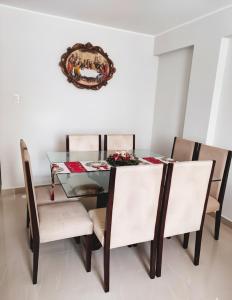 einem Esstisch mit Stühlen und einem Teller an der Wand in der Unterkunft Amplio departamento en Ica in Ica + 7 Fotos