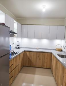 eine weiße Küche mit Holzschränken und einem Waschbecken in der Unterkunft Amplio departamento en Ica in Ica